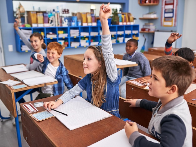 質問に答えたいと思っているすべてのクラスの小学生のクロップドショット