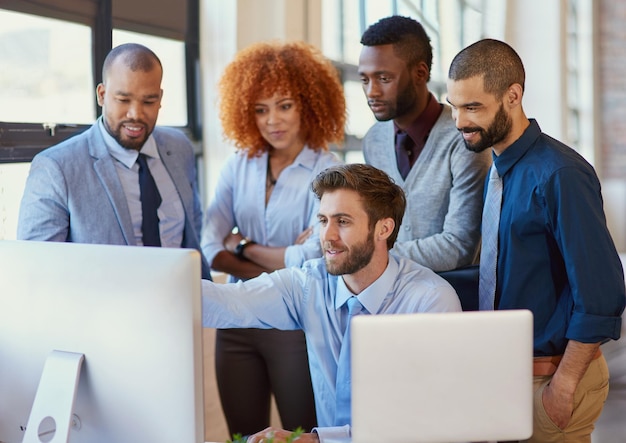 Tutte le mani sul ponte ripresa di un gruppo di uomini d'affari che lavorano insieme a un computer in ufficio