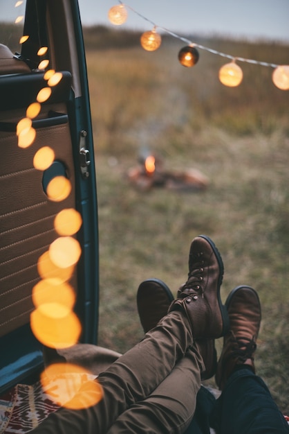 All they need is each other.  Close up of young couple resting inside of the retro style minivan while enjoying their road travel