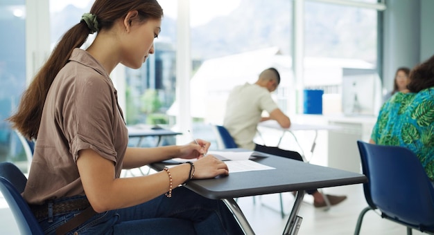 Tutto il domani ha da offrire inquadratura di una giovane studentessa che completa l'esame in una classe all'università