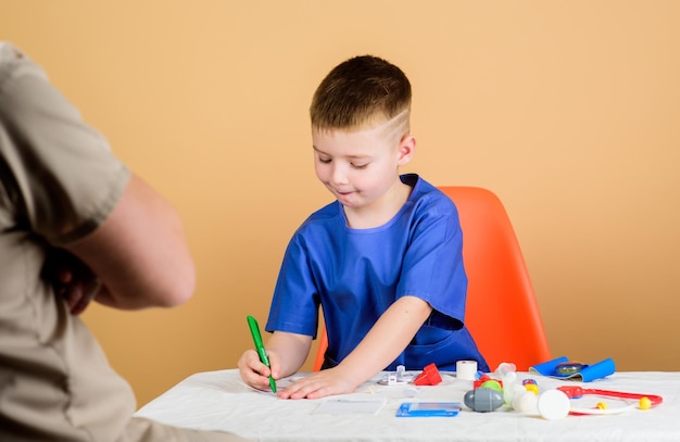 Tutto ciò di cui hai bisogno per la tua salute ragazzino con papà gioca futura carriera padre e figlio in uniforme medica bambino con padre con stetoscopio infanzia genitorialità medico di famiglia medicina e salute