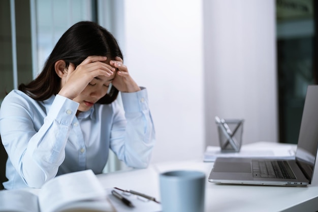 Alleen aan het werk Laat-Aziatische zakenvrouw op de werkplek op kantoor legde haar hoofd op de tafel en viel in slaap voor de laptop
