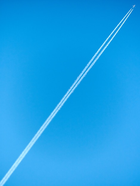 Foto alleen vliegtuig in blauwe paarse hemel trace witte diagonale lijn