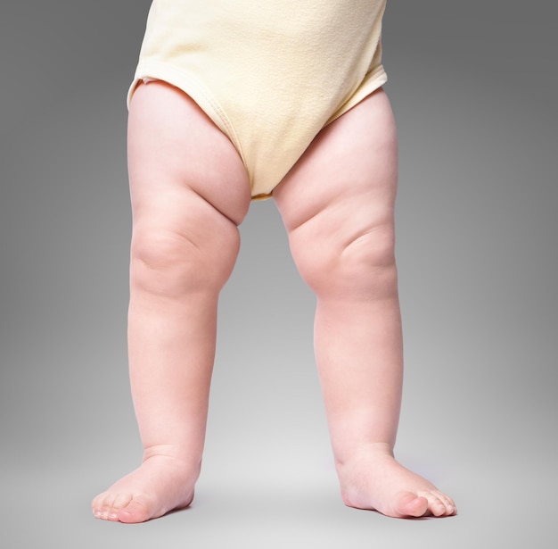 Alleen voet, baby gaat op de achtergrond. op een grijze achtergrond