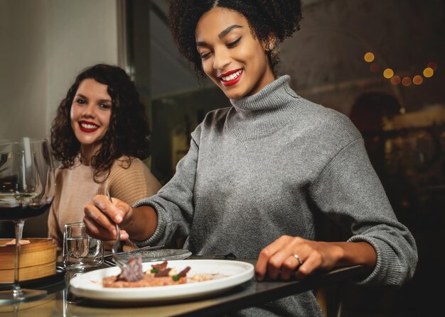 Alleen vrouwen - biraciale vriendinnen eten in fusion food restaurant