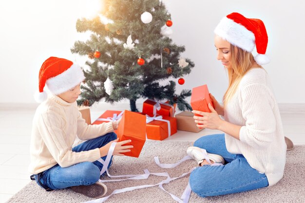 Alleenstaande ouder en vakantieconcept - Portret van moeder en zoon die Kerstmis thuis vieren op kerstavond