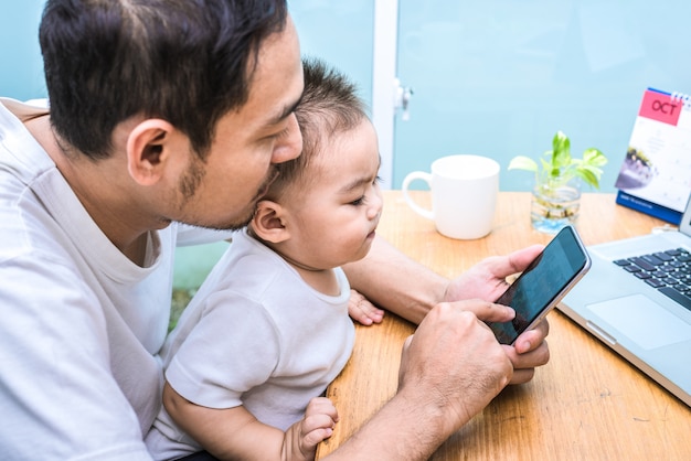 Alleenstaande vader en zoon met behulp van laptop samen gelukkig. Technologie en leefstijlen concept.