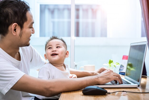 Alleenstaande vader en zoon met behulp van laptop samen gelukkig