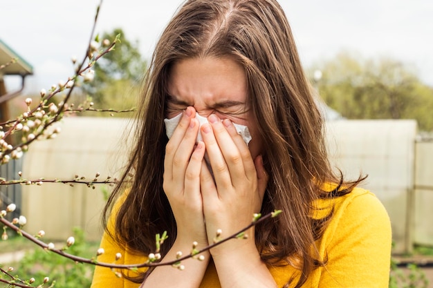 Foto allergisch tienermeisje bij een bloeiende boom