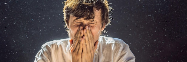 Allergia alla polvere un uomo starnutisce perché è allergico alla polvere la polvere vola nell'aria in controluce