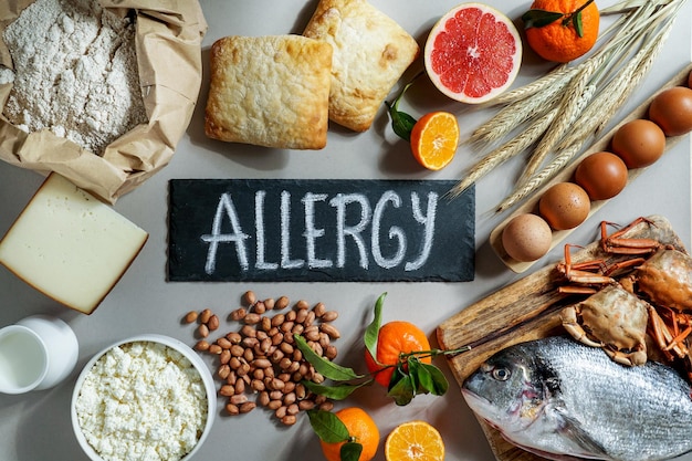 Photo allergy food concept allergene milk fish strawberry bread eggs peanuts citrus wheat flower and others on grey backgrond