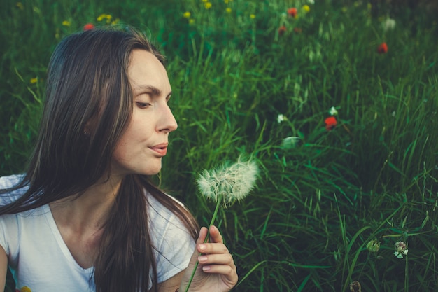 Allergy free concept. Woman blowing dandelion