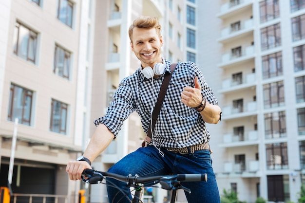 Alles is perfect. Gelukkig vreugdevolle man Ok teken tonen tijdens het fietsen