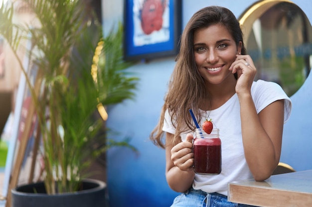 Seducente ragazza civettuola carina abbronzata bruna tocca la guancia gioia