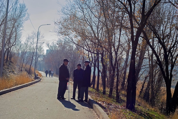 Almaty Kazakhstan 11132022 Two old friends standing on in park and talking to each other