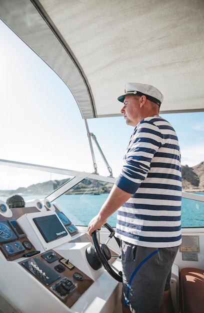 Almaty kazakhstan 26052020 the captain of the yacht at the helm
controls the boat on the water