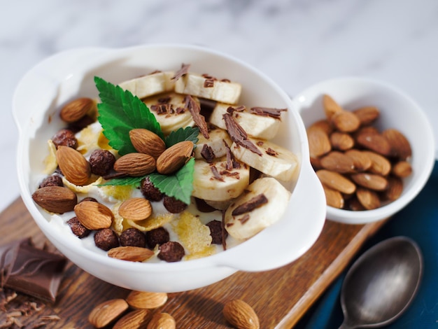 Almond banana salad with chocolate and milk in white plate Healthy nutritious breakfast Top view Still life Background