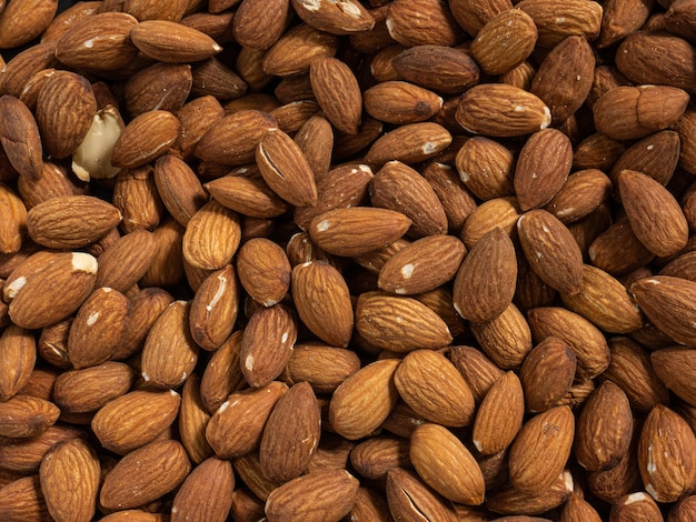 The almond in black plate on wood table for food and health  concept