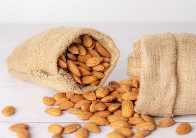 Almond in cloth bag on blurred white table