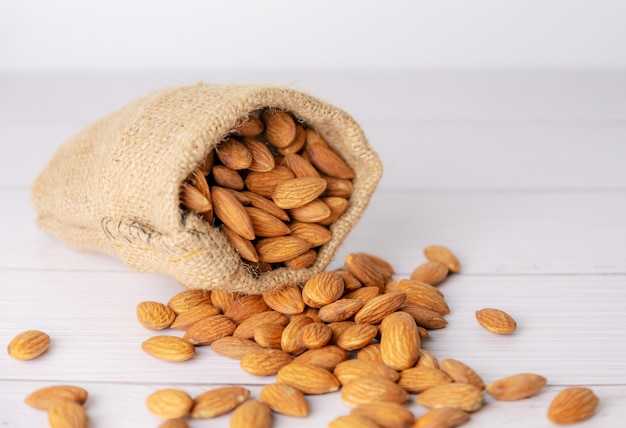 Almond in cloth bag on blurred white table