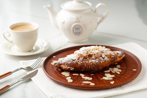 Photo almond croissant on clay plate close up