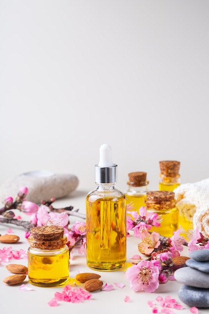 Almond essential oil in a bottles with spring blossom branches