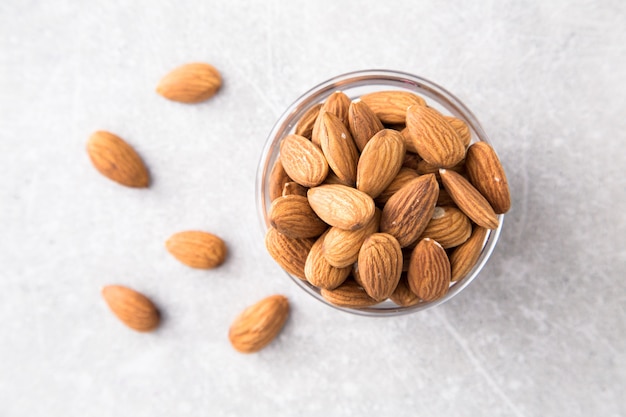 Almond in the glass bowl on stone table.