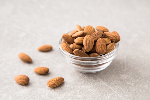 Almond in the glass bowl on stone table.