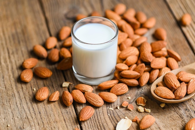 Latte di mandorla e noci di mandorle sullo sfondo di legno deliziose mandorle dolci sul tavolo dado di mandorle tostate per cibo sano e snack