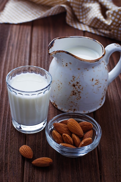 Almond milk and almonds on wooden background 