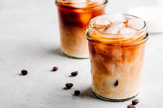 Almond Milk Cold Brew Coffee Latte in glass jar on a gray stone background