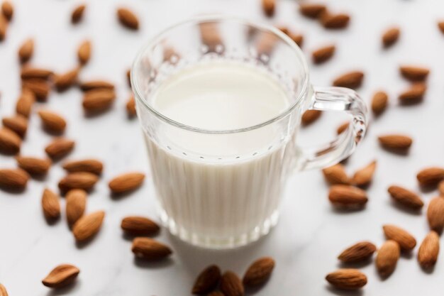 Almond milk in a glass surrounded by organic almonds