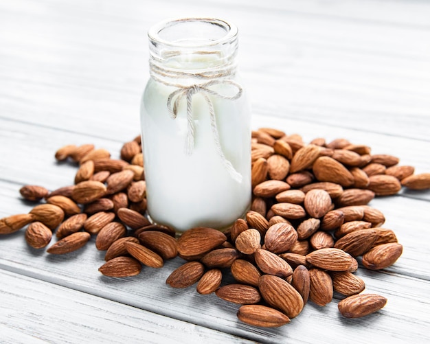 Almond milk with almonds on a wooden table