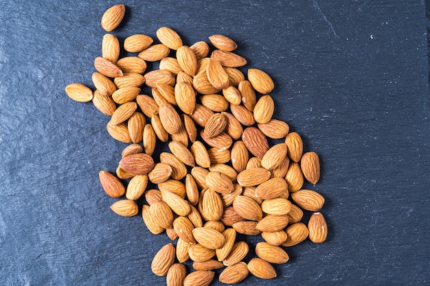 Photo almond nuts on gray background.