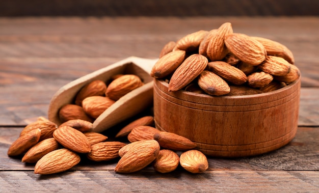 Almond nuts in a plate close-up on a wooden background