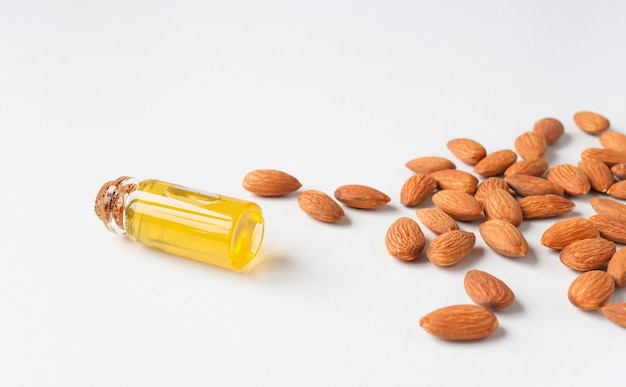 Almond oil in a bottle with scattered almonds