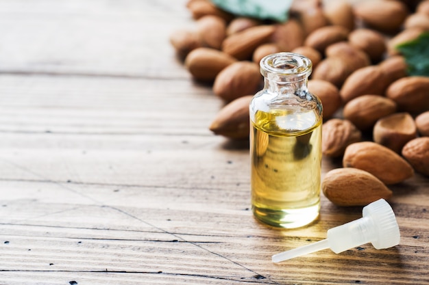 Almond oil in bottle on wooden table. Concept Spa, aromatherapy and medicine.