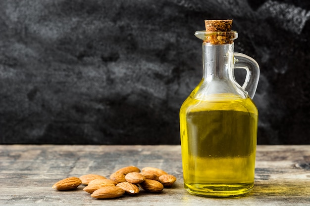 Almond oil in bottle on wooden table 