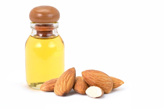 Almond oil in glass bottle and group of almond nuts isolated on white background.