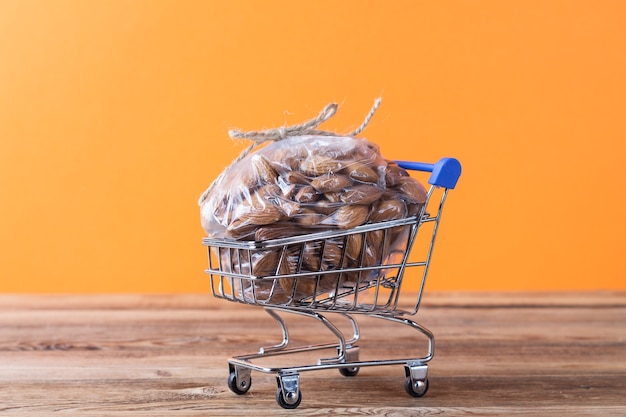 Photo an almond in a plastic bag in a shopping cart