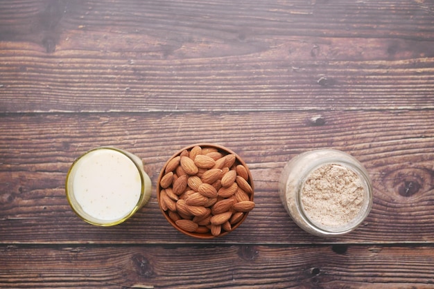 Almond powder and almond in a jar on table