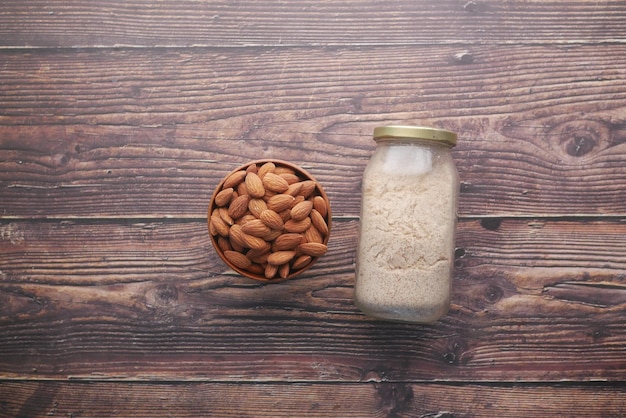 Almond powder and almond in a jar on table