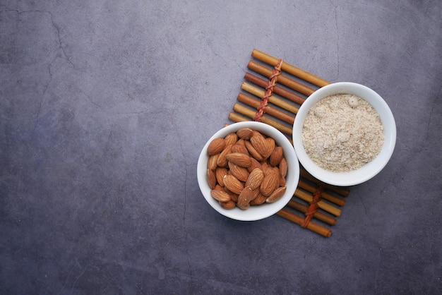 Almond powder and almond in a jar on table