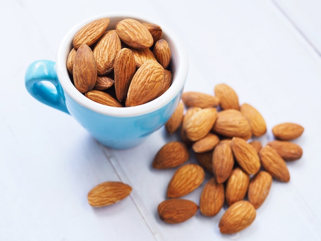 Almond seeds in blue cup isolated