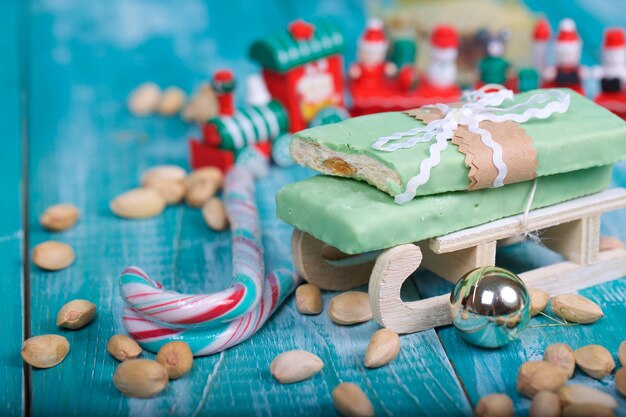 Foto torrone di mandorle ricoperto di cioccolato al pistacchio su una superficie di legno. avvicinamento