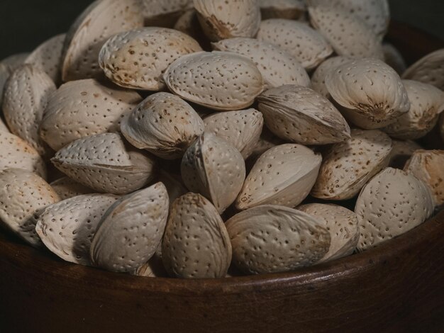 Photo almond with wooden bowl low light photography