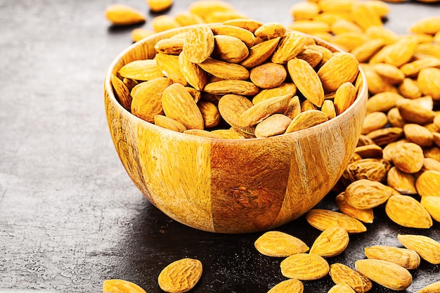 Almond in wooden bowl standing on rustic