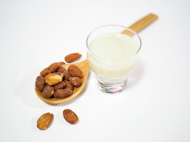 Almond in wooden spoon and glass of almond milk best for health