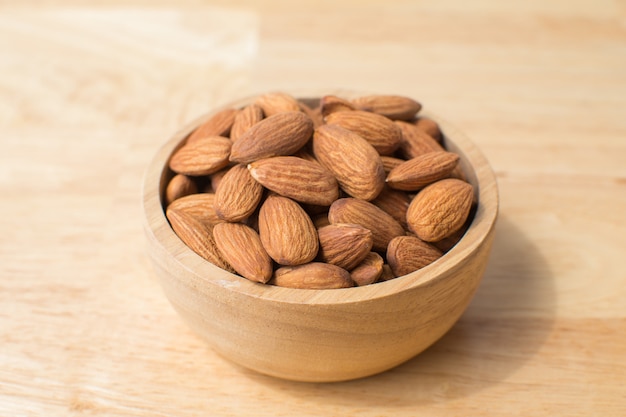 Photo almond on wooden table. soft focus.