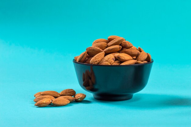 Photo almonds bowl on blue